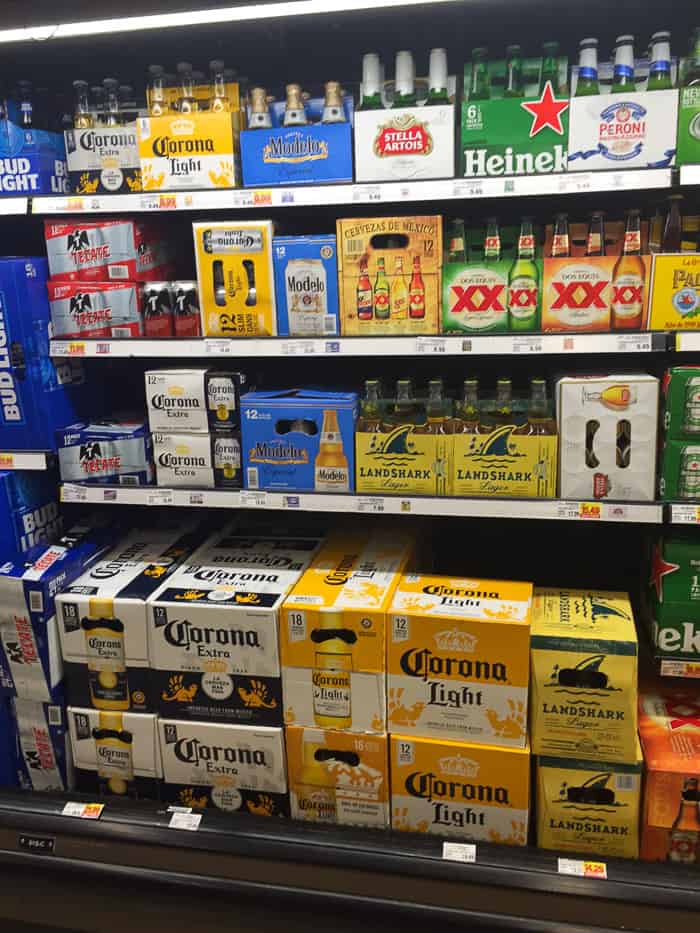 The beer display on refrigerated supermarket shelves.