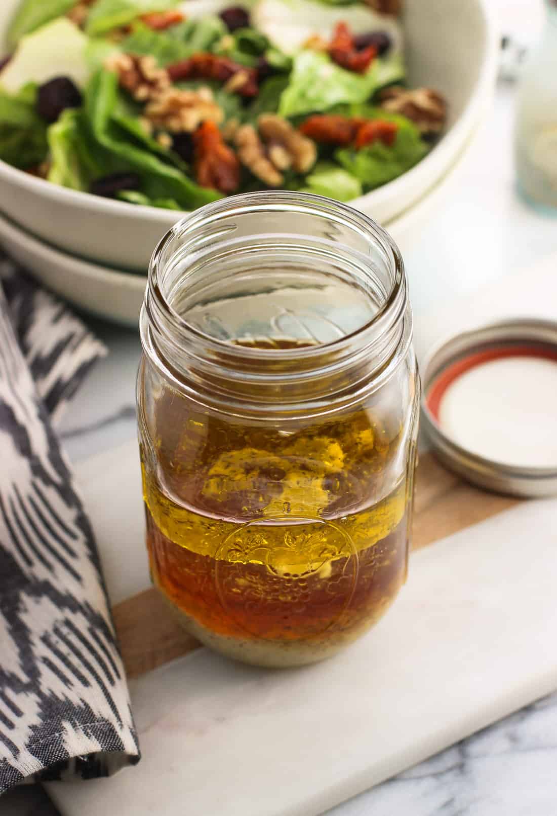 All of the vinaigrette ingredients poured into a mason jar, before being shaken