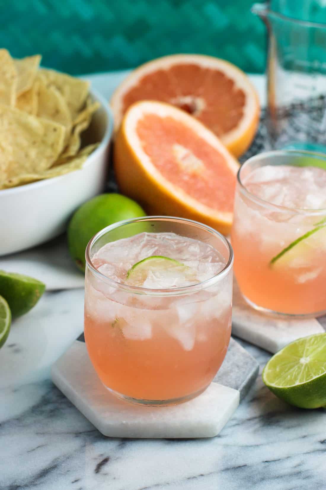 Grapefruit vodka sodas on marble coasters.