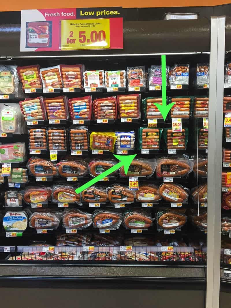 The smoked sausage packages on the refrigerated supermarket shelves.