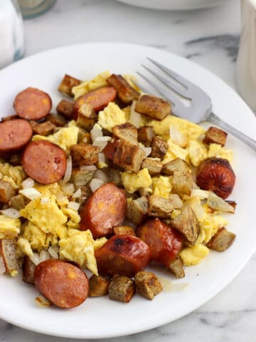 A serving of the sausage and egg scramble on a plate with a fork.