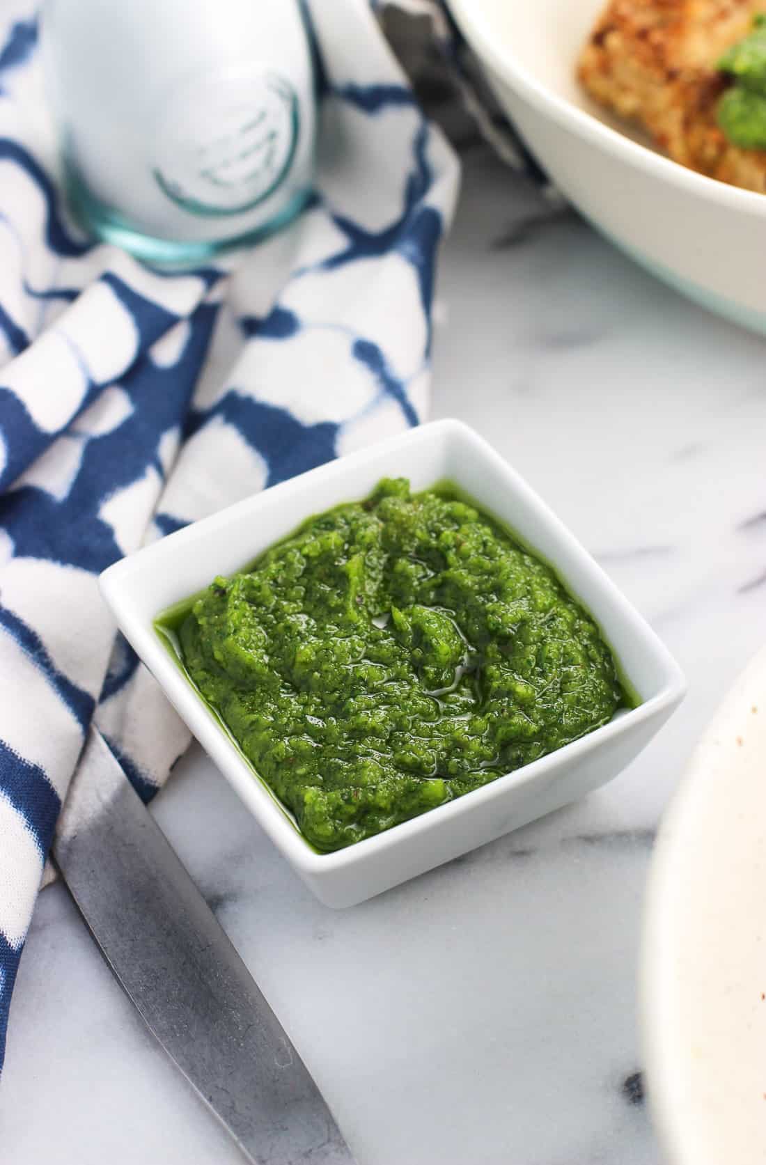 A small ceramic dish filled with parsley pesto