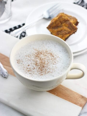 A chamomile tea latte in a large cup with cinnamon sprinkled on top.