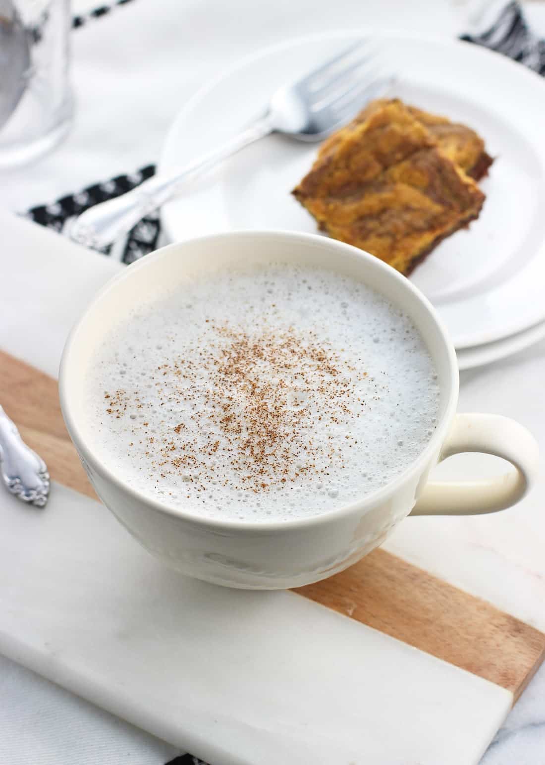 Un latte alla camomilla in una tazza grande con cannella spruzzata sulla parte superiore.