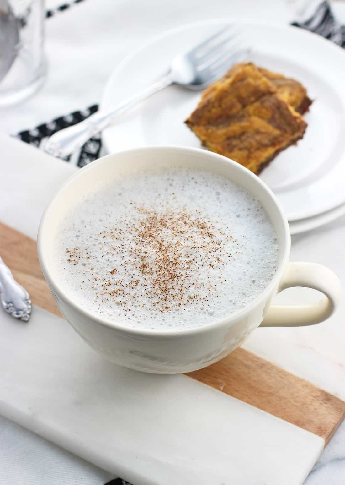 A chamomile tea latte in a large cup with cinnamon sprinkled on top.