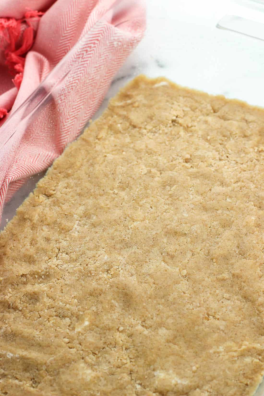 The bottom layer of the bars pressed into a 9" x 13" clear glass baking dish