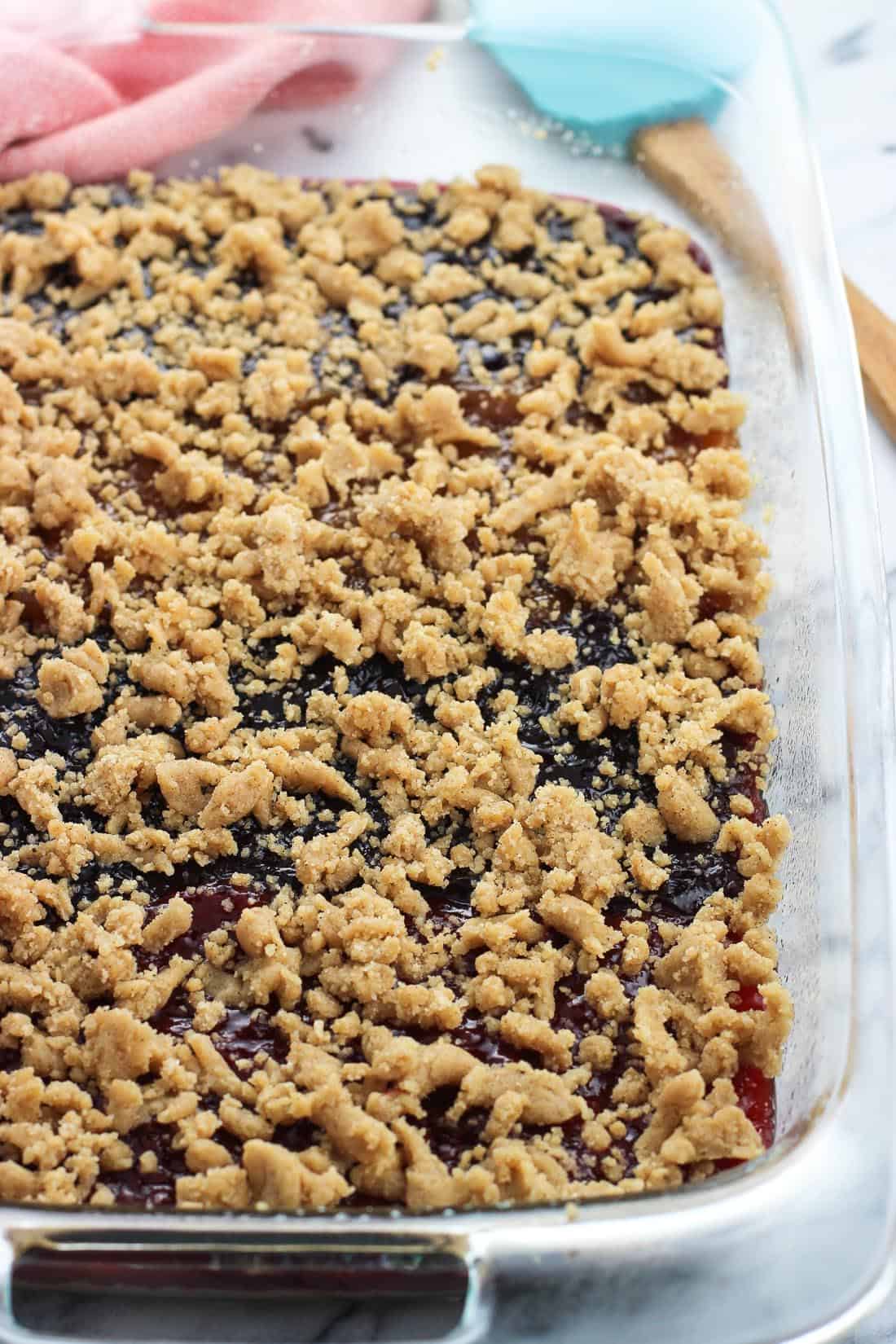 The bars in the baking dish, with the second half of the mixture crumbled on top of the jam, just prior to being baked