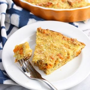 A slice of zucchini pie on a plate with a piece speared on a fork.