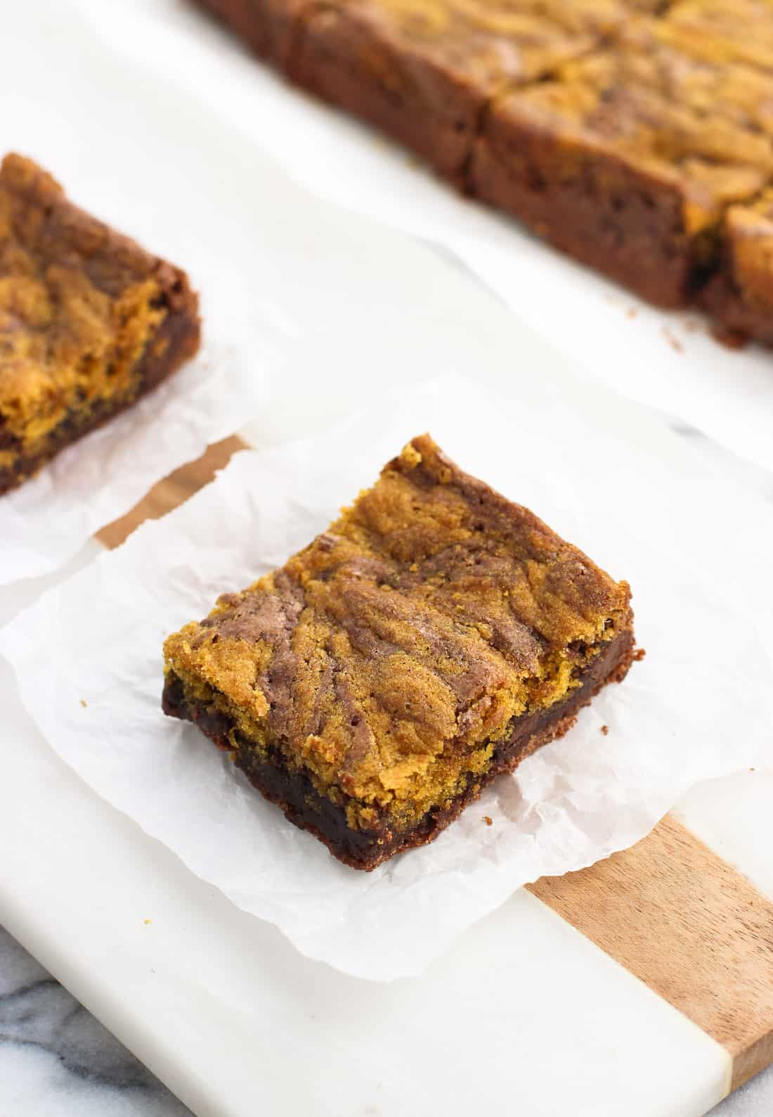 A brownie on a square of crinkled parchment paper.