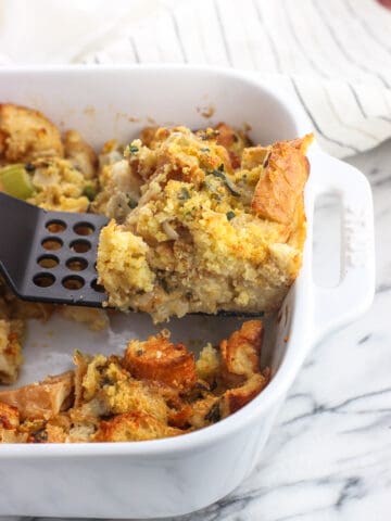 A slice of strata being lifted out of the baking dish by a spatula