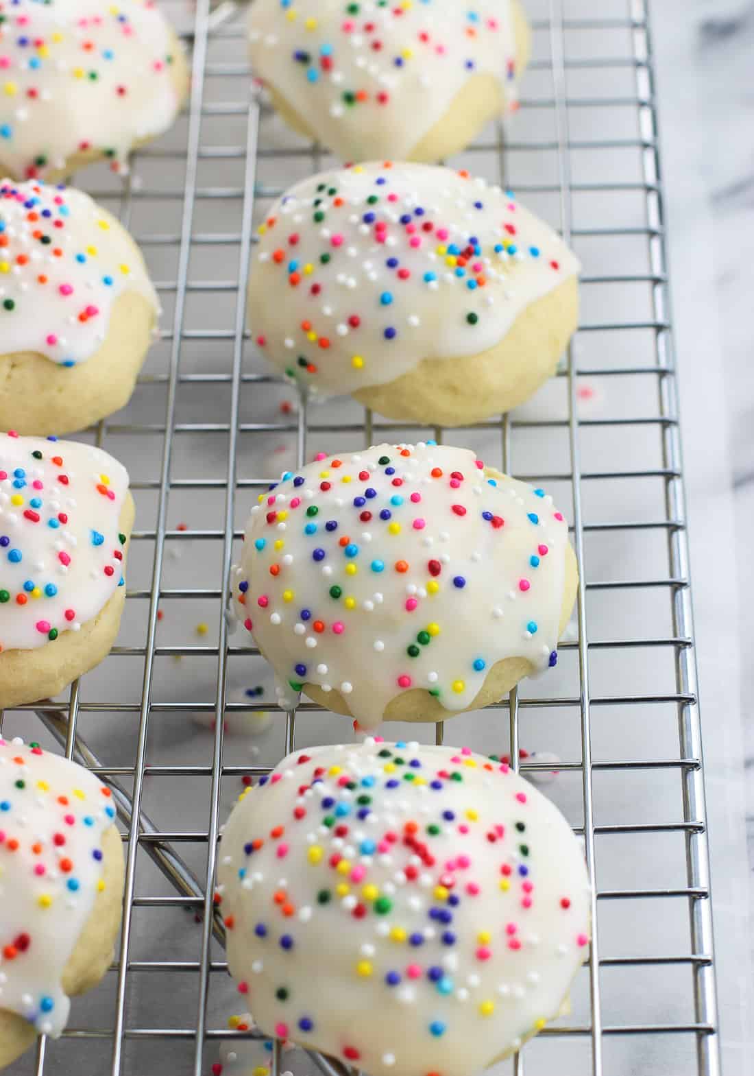 Iced anisette cookies lined up on a wire rack.