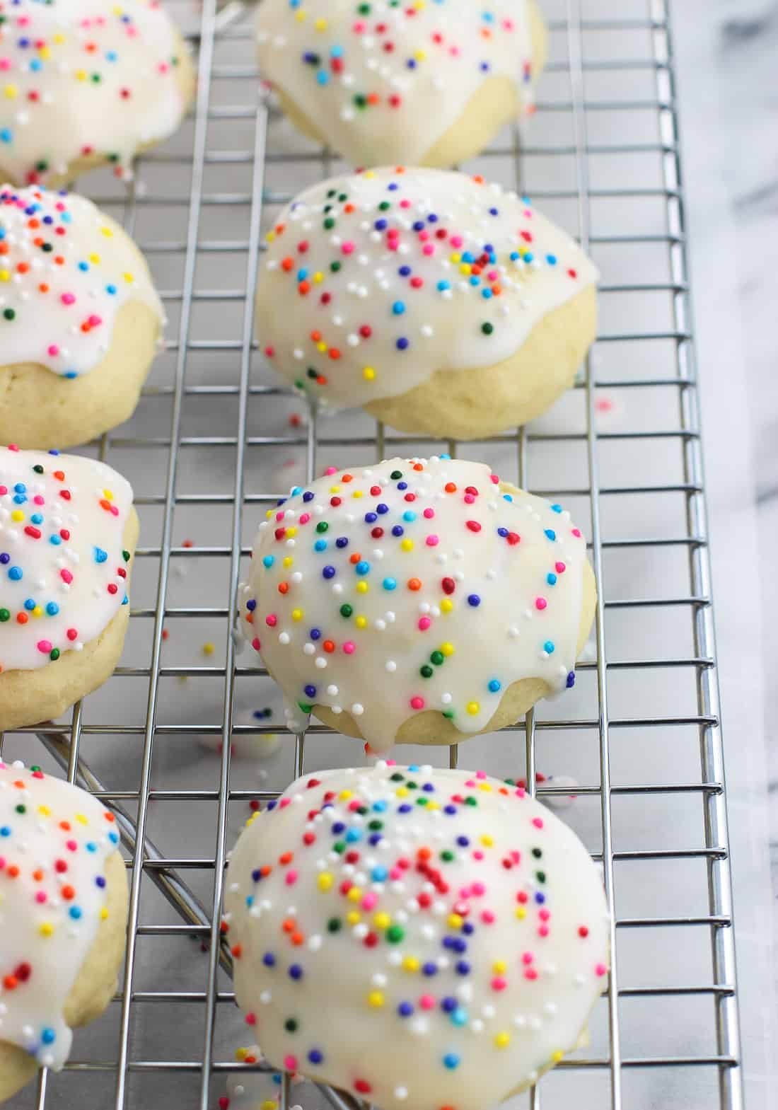 Iced anise cookies lined up on a wire rack.