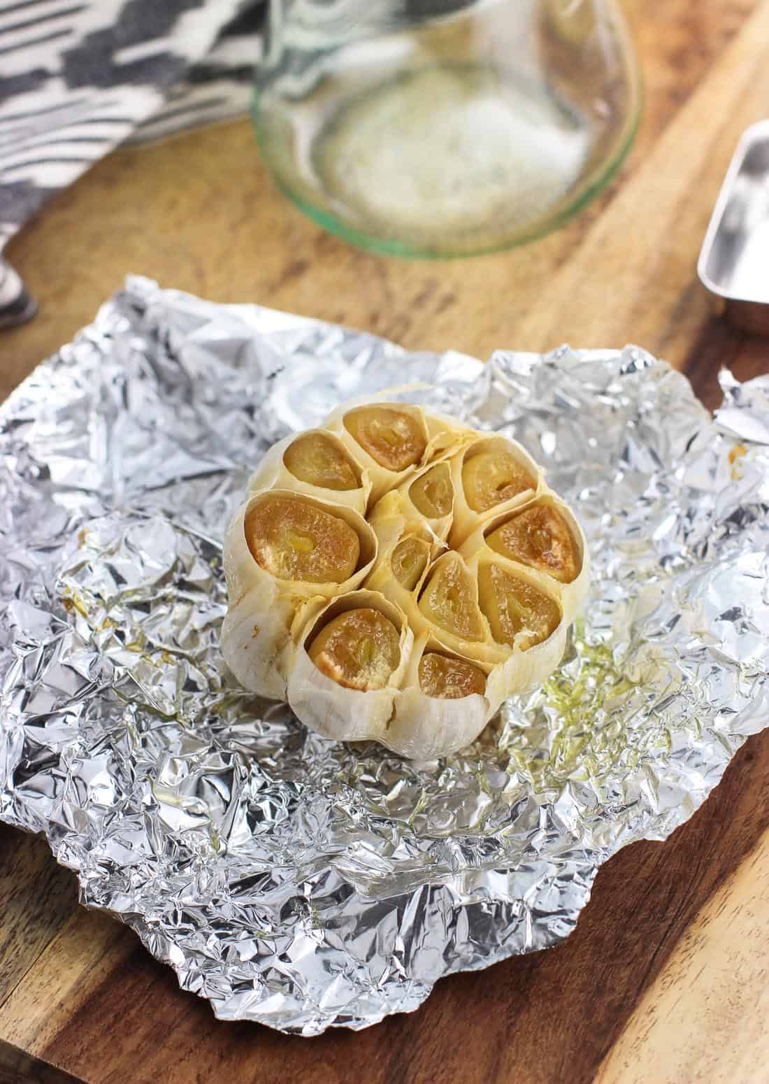 The head of garlic now roasted unwrapped from the foil