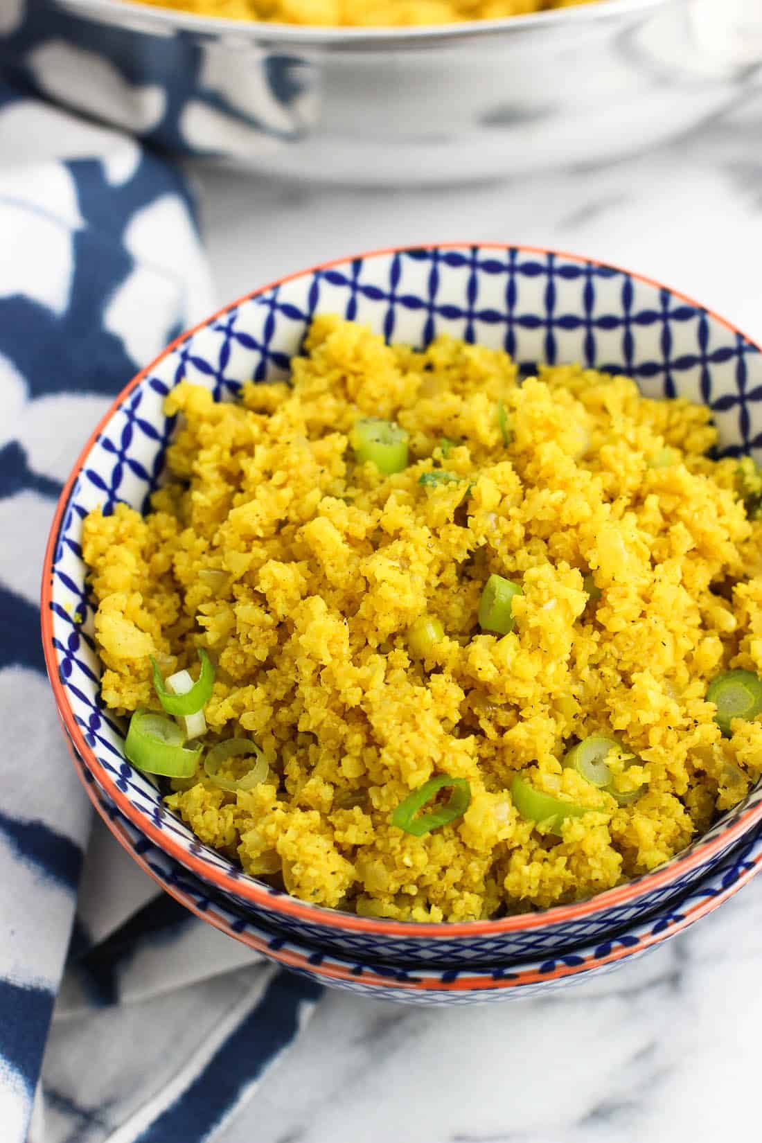A serving of turmeric cauliflower rice in a small ceramic bowl.