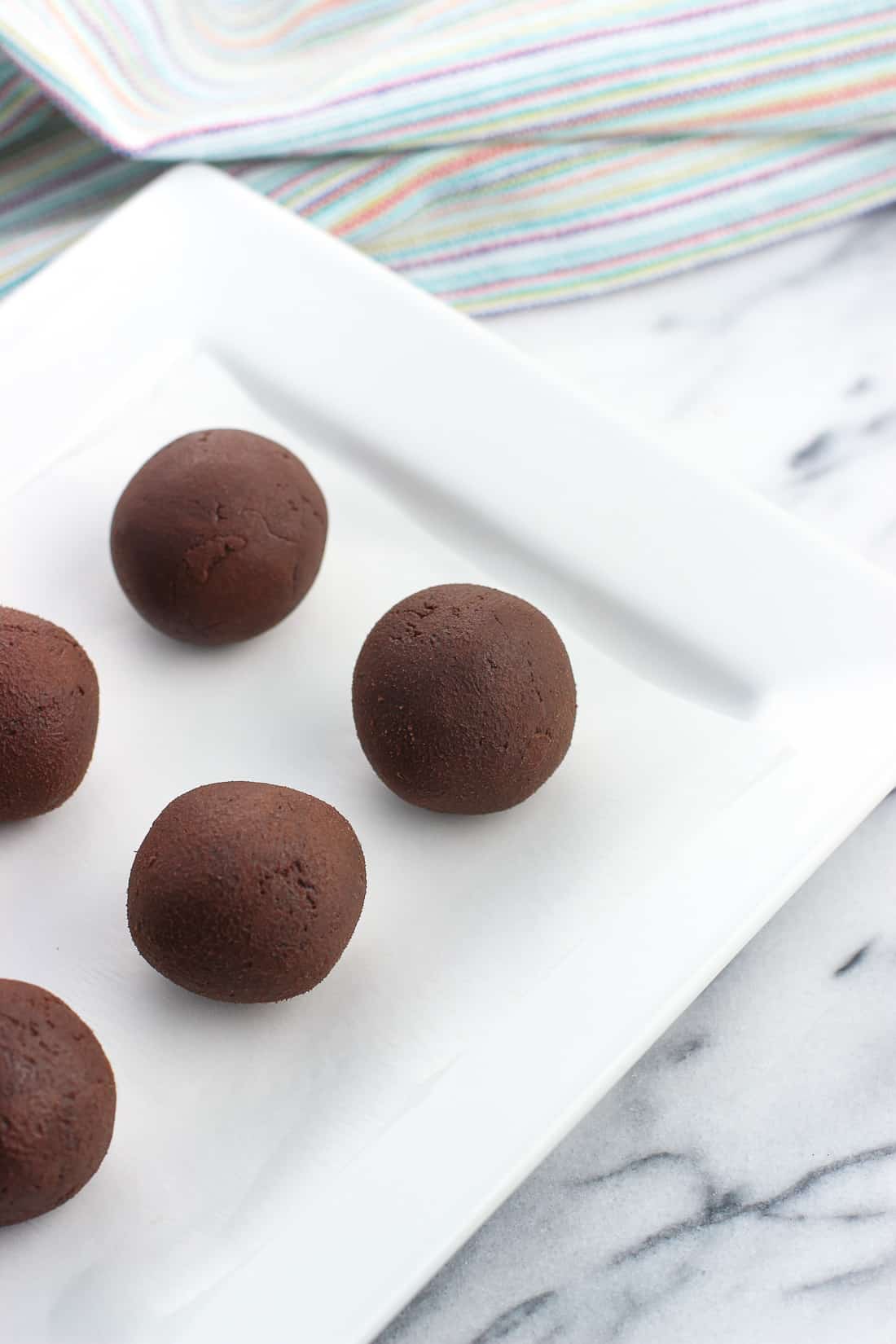 Truffles rolled on a ceramic tray before being coated in cocoa powder