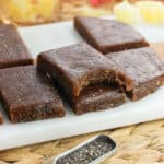 Chia bars stacked on top of one another with a bite taken out of the top bar.