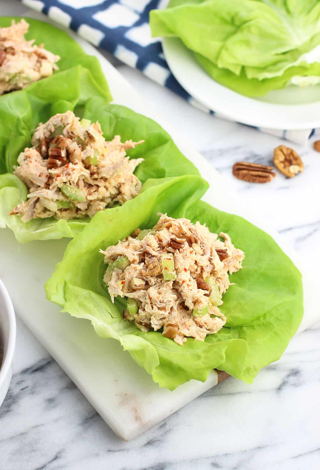 Three chicken salad lettuce wraps on a tray.