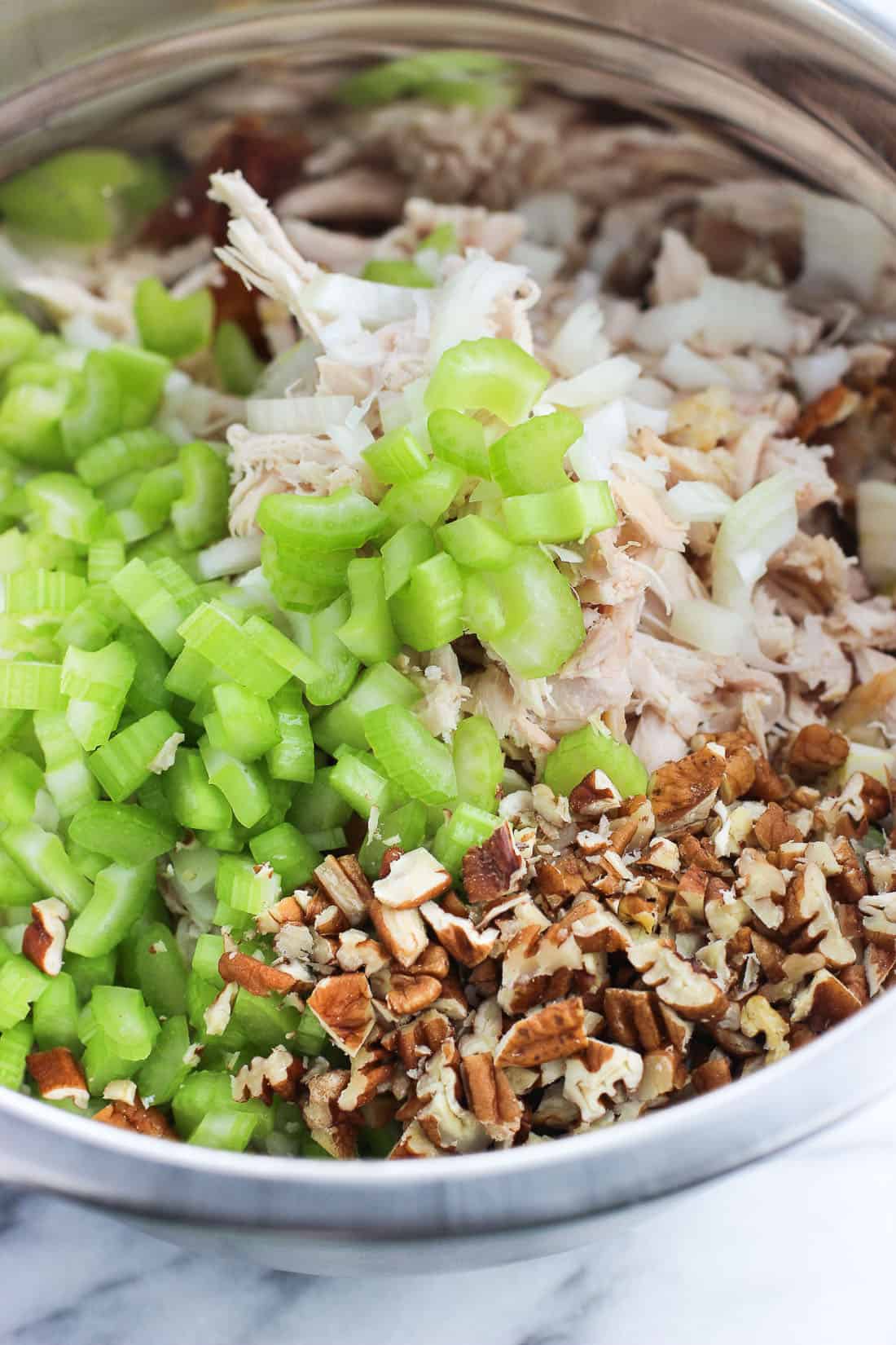 Chicken, pecans, celery, and onion in a mixing bowl.