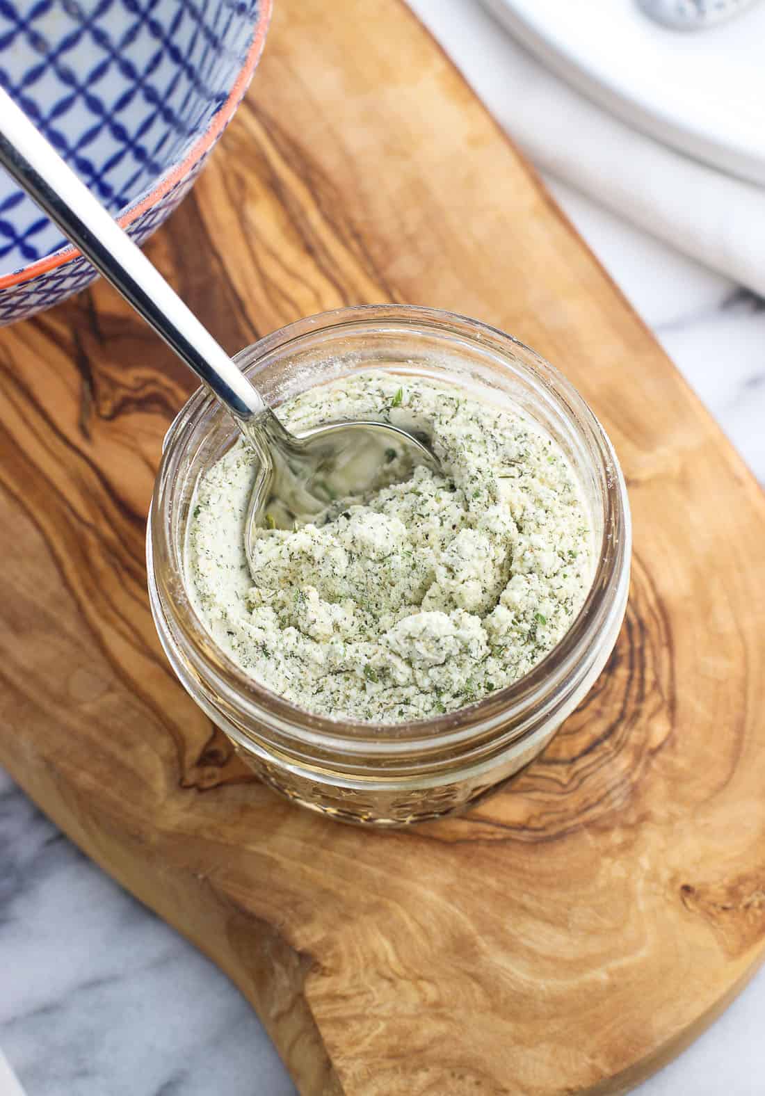 A spoon plunged in the jar of ranch seasoning.