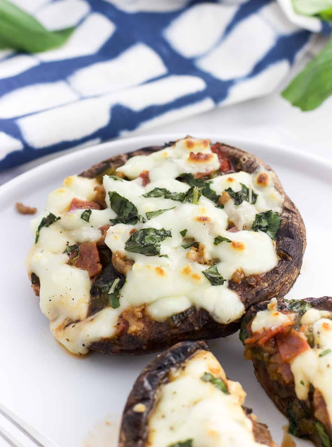 A close-up of a portobello pizza topped with basil.