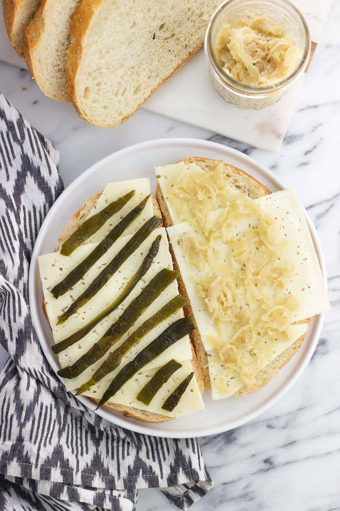 An open face sandwich on a plate before cooking.
