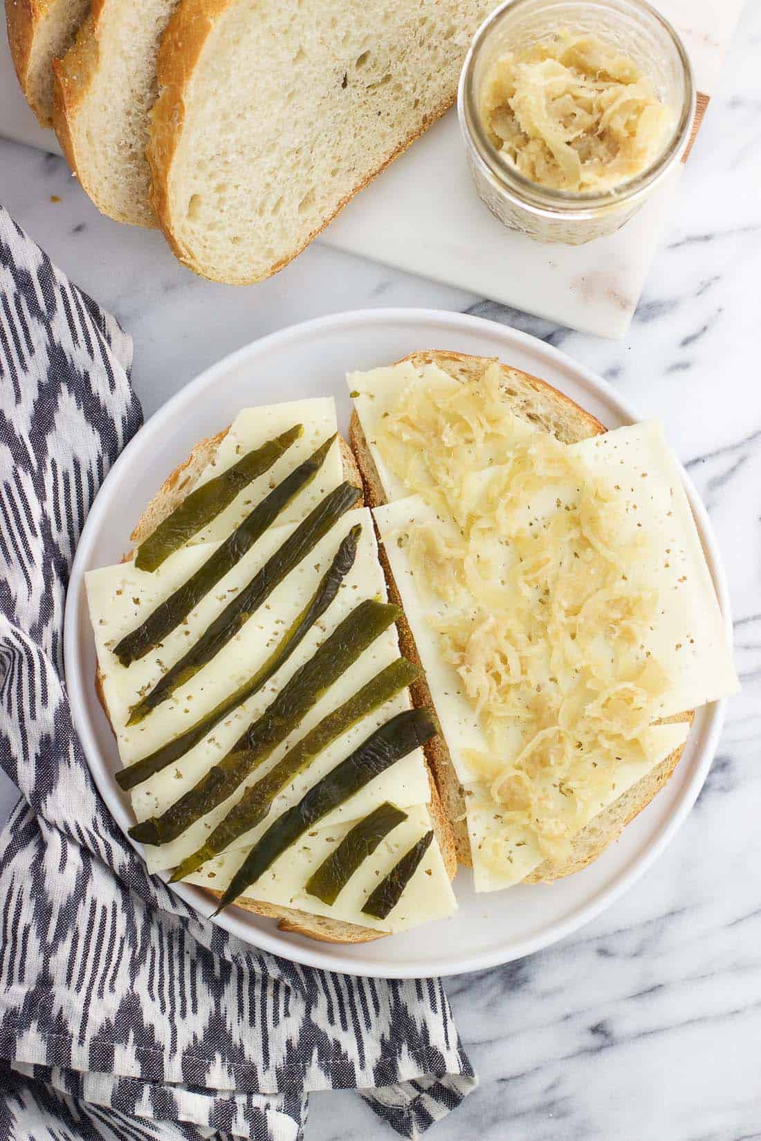 An open face sandwich on a plate before cooking.