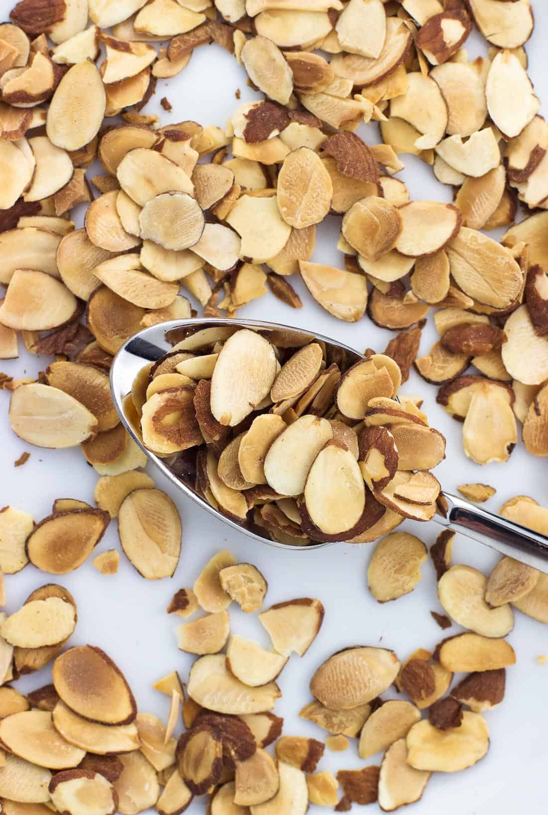 Toasted almond slices on a plate with a spoon