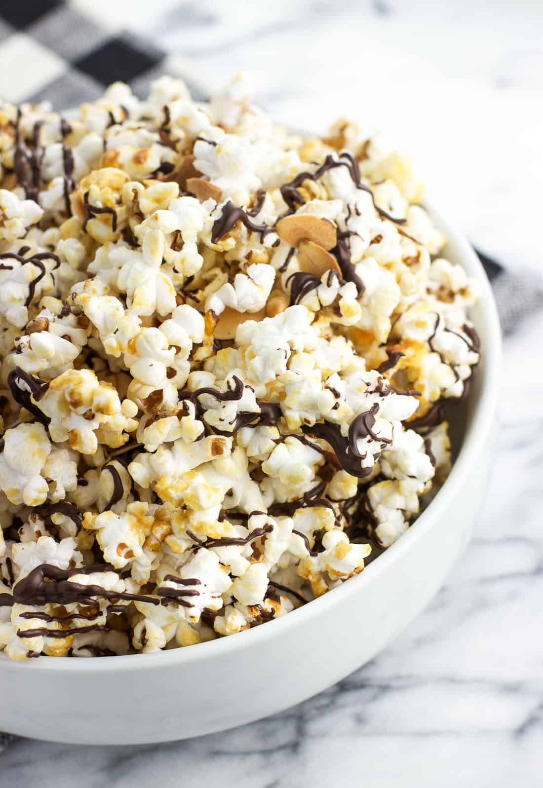 A close-up of chocolate drizzled popcorn in a serving bowl