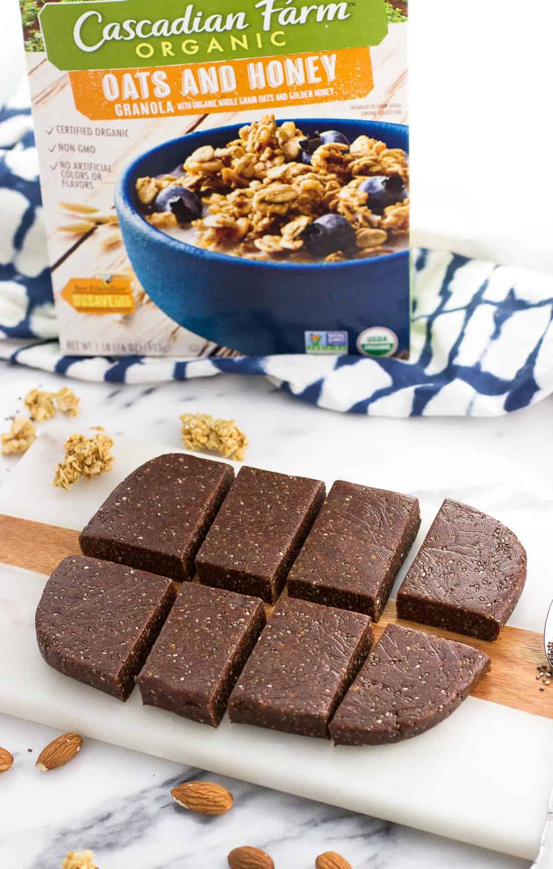 Eight sliced bars on a marble board with a box of granola in the background