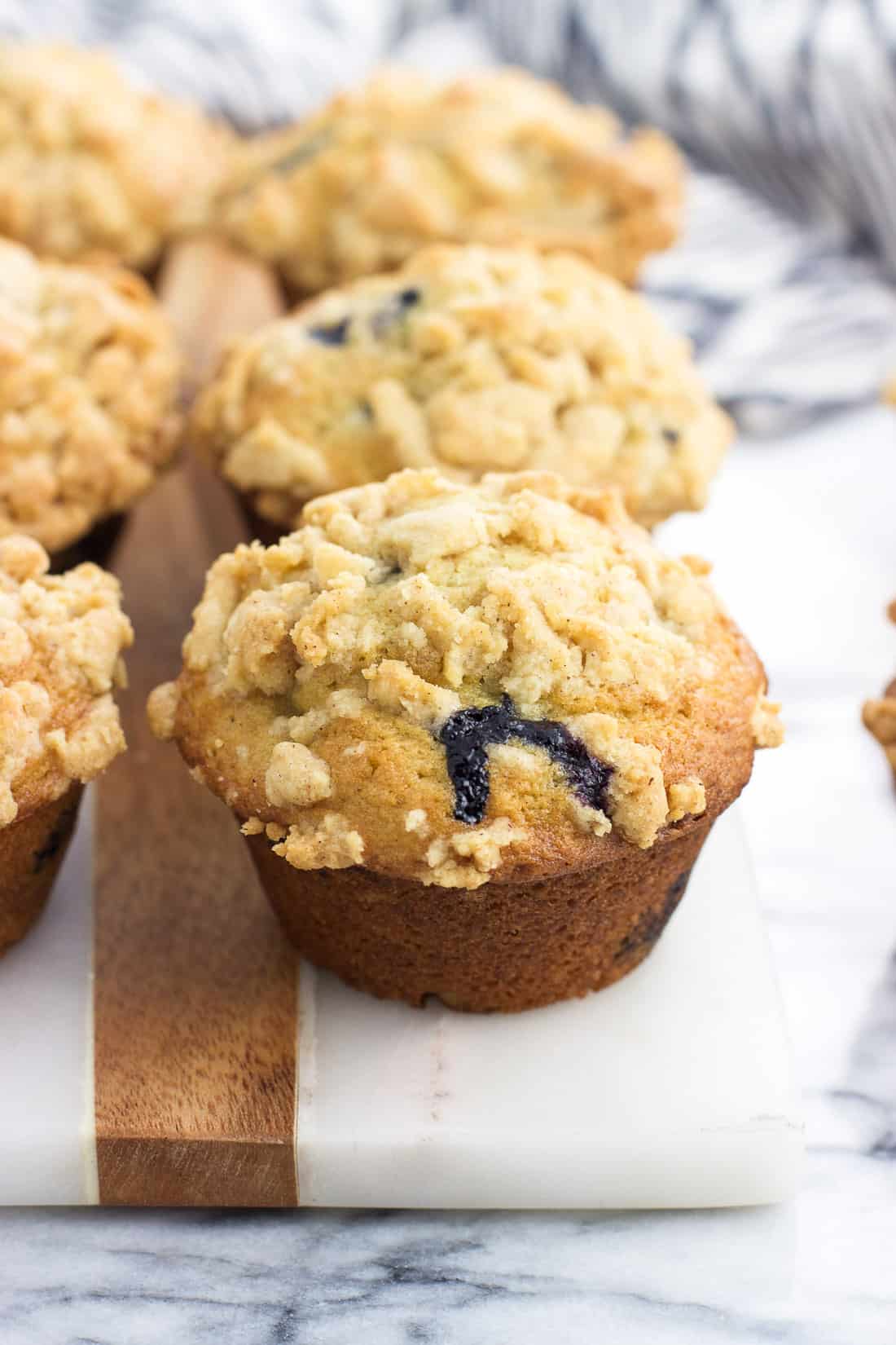 Six muffins lined up on a marble board ready to eat