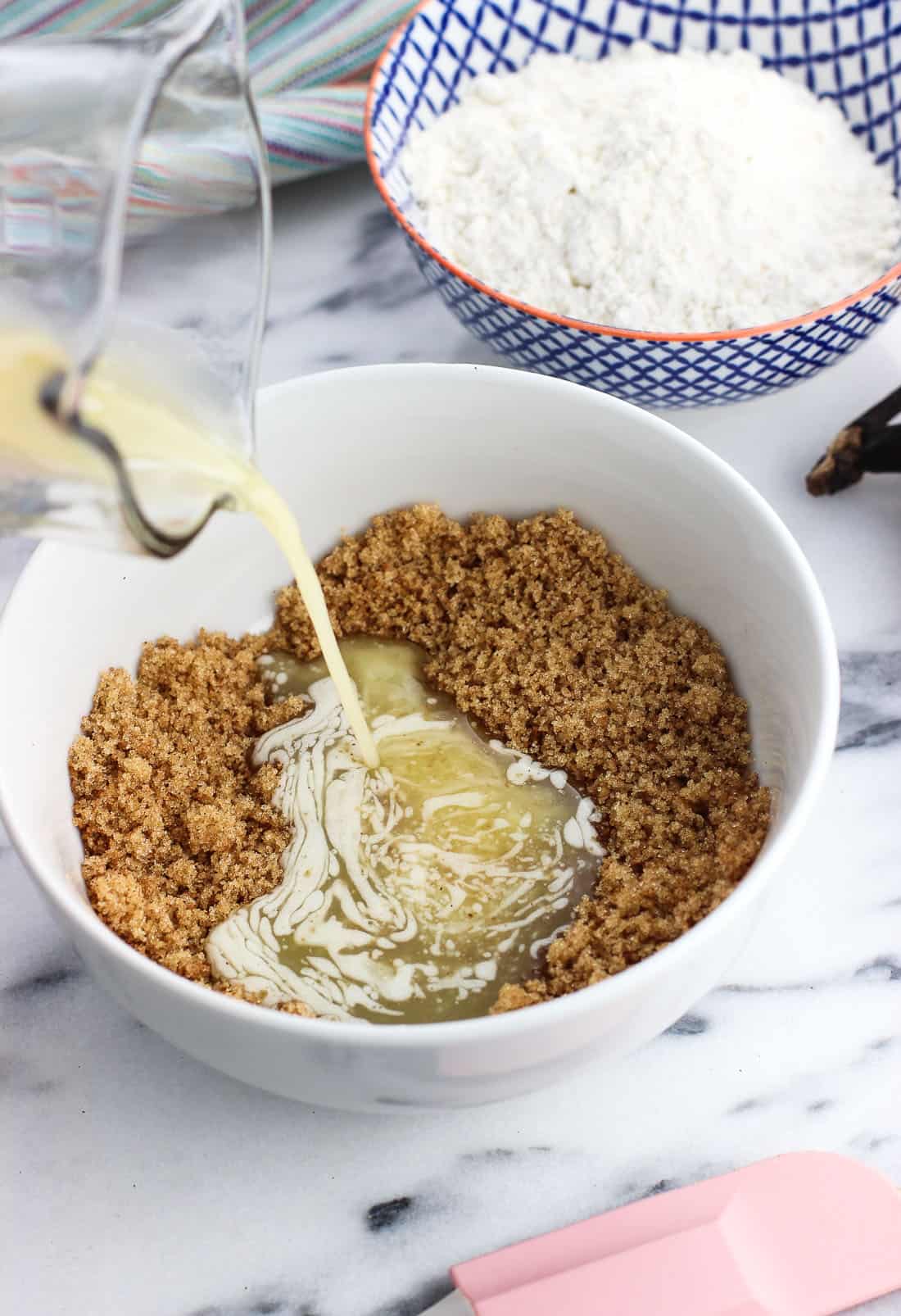 Melted butter being poured into a bowl over brown sugar and cinnamon.