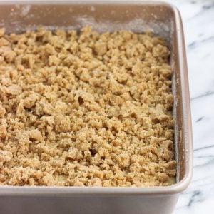 Cake batter in a baking dish topped with crumb topping.