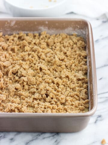Cake batter in a baking dish topped with crumb topping.