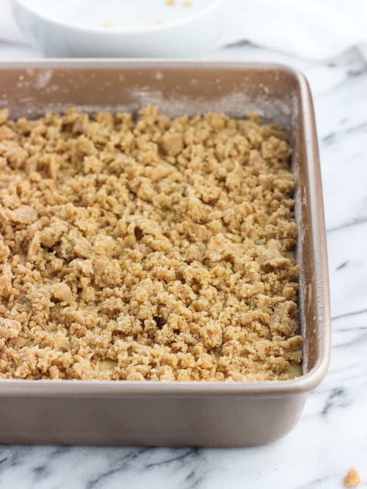 Cake batter in a baking dish topped with crumb topping.