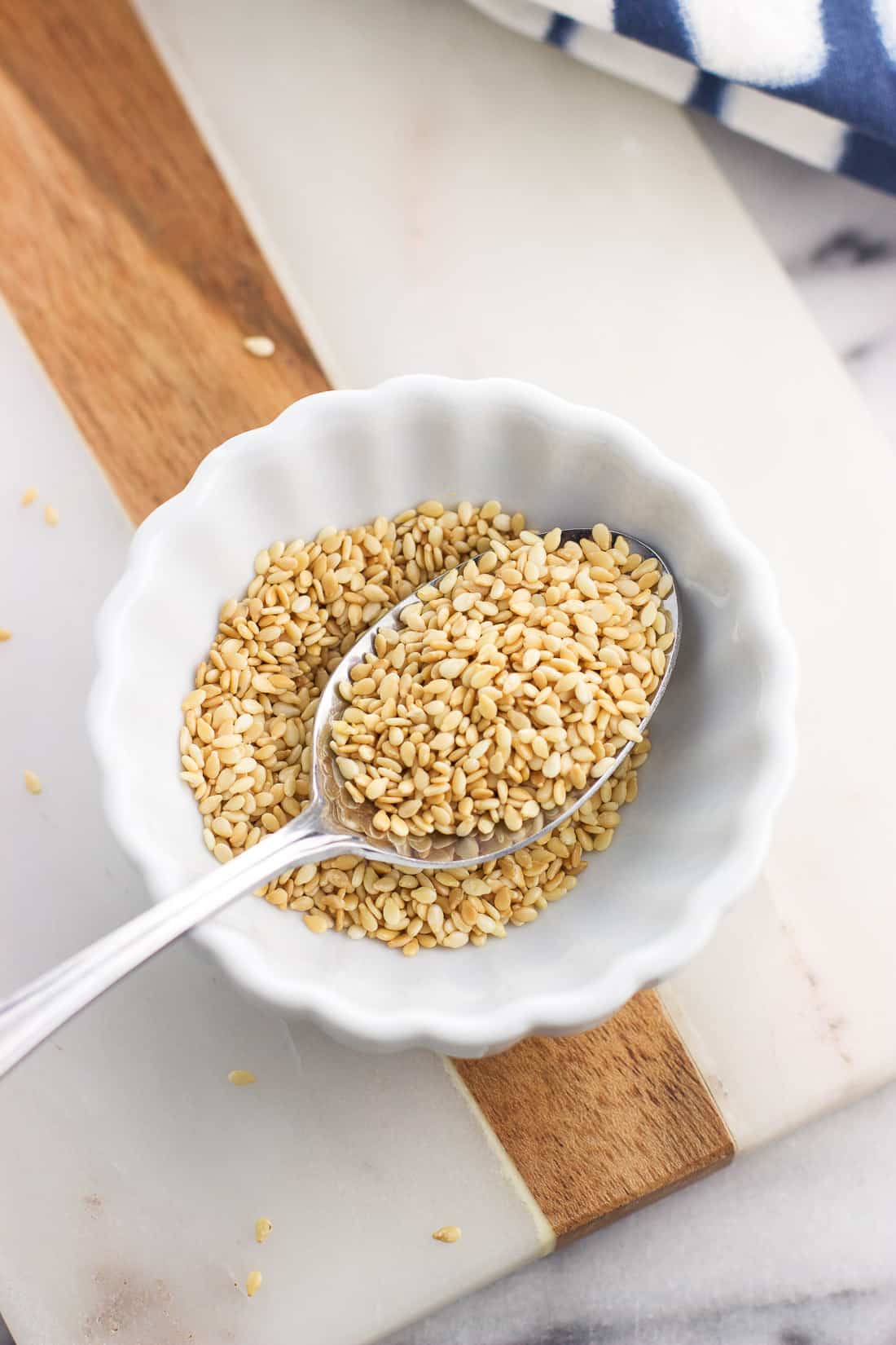 Toasted sesame seeds in a small bowl with a spoon
