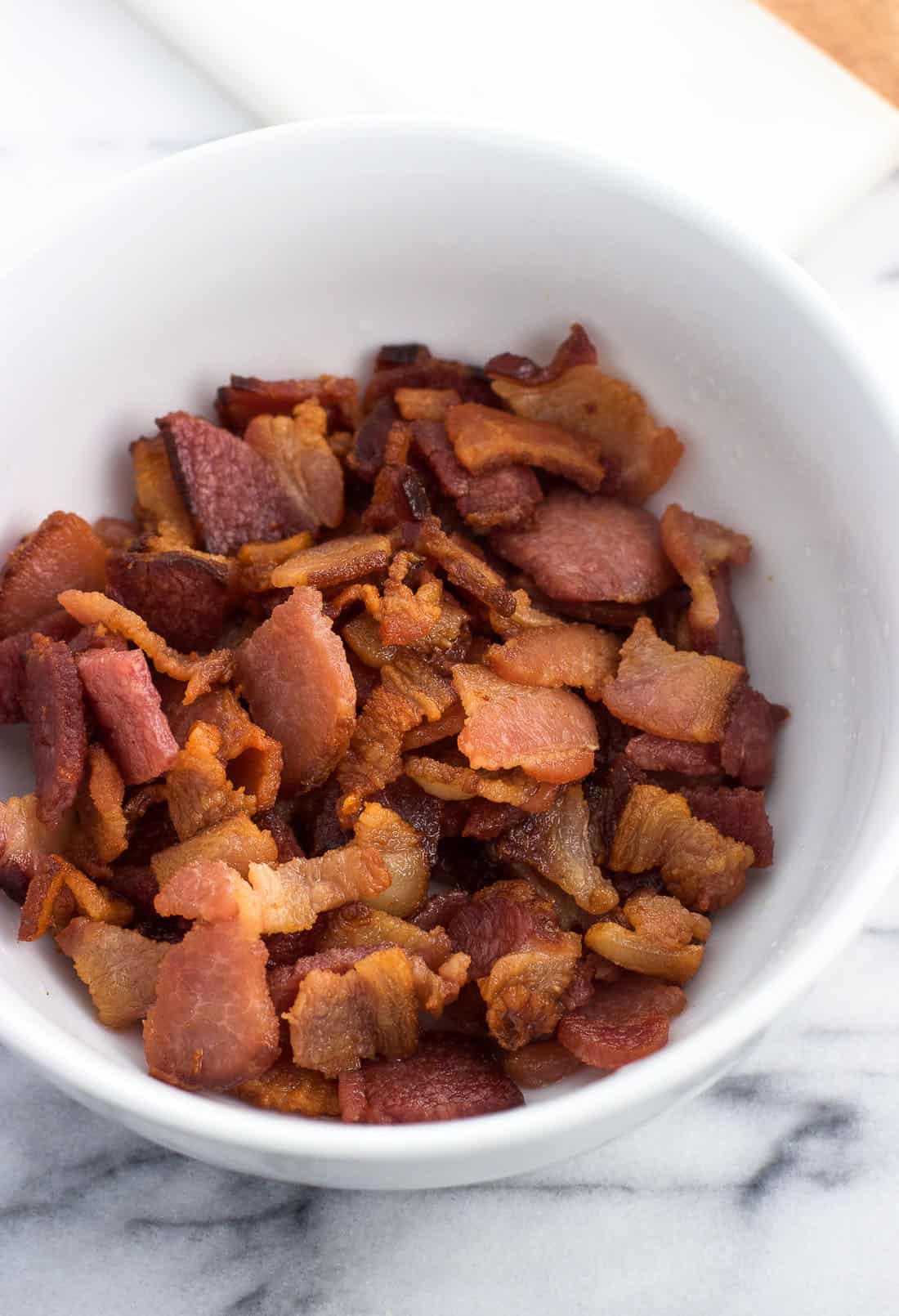 A bowl of cooked and crumbled bacon.