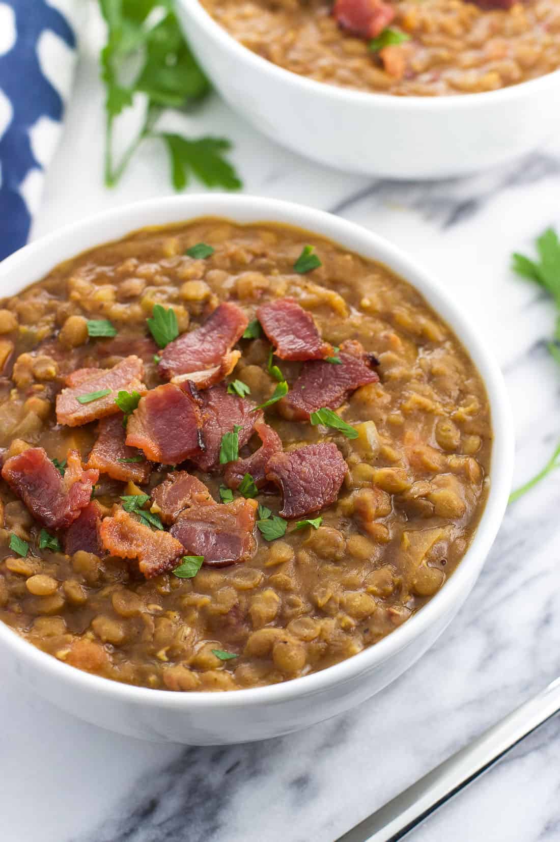 A bowl of lentil soup topped with crumbled bacon.