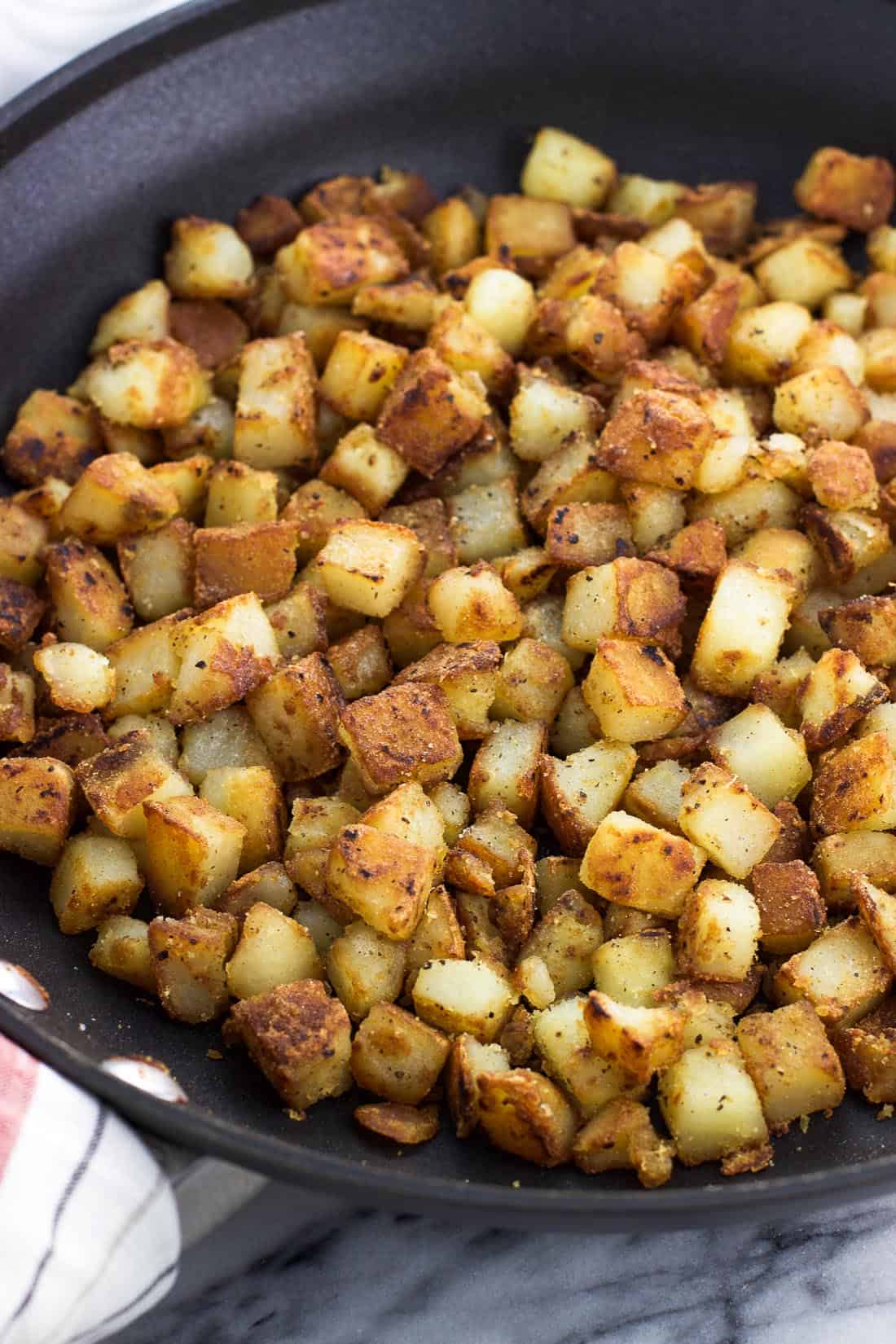 Cubed and sauteed potatoes in a skillet.