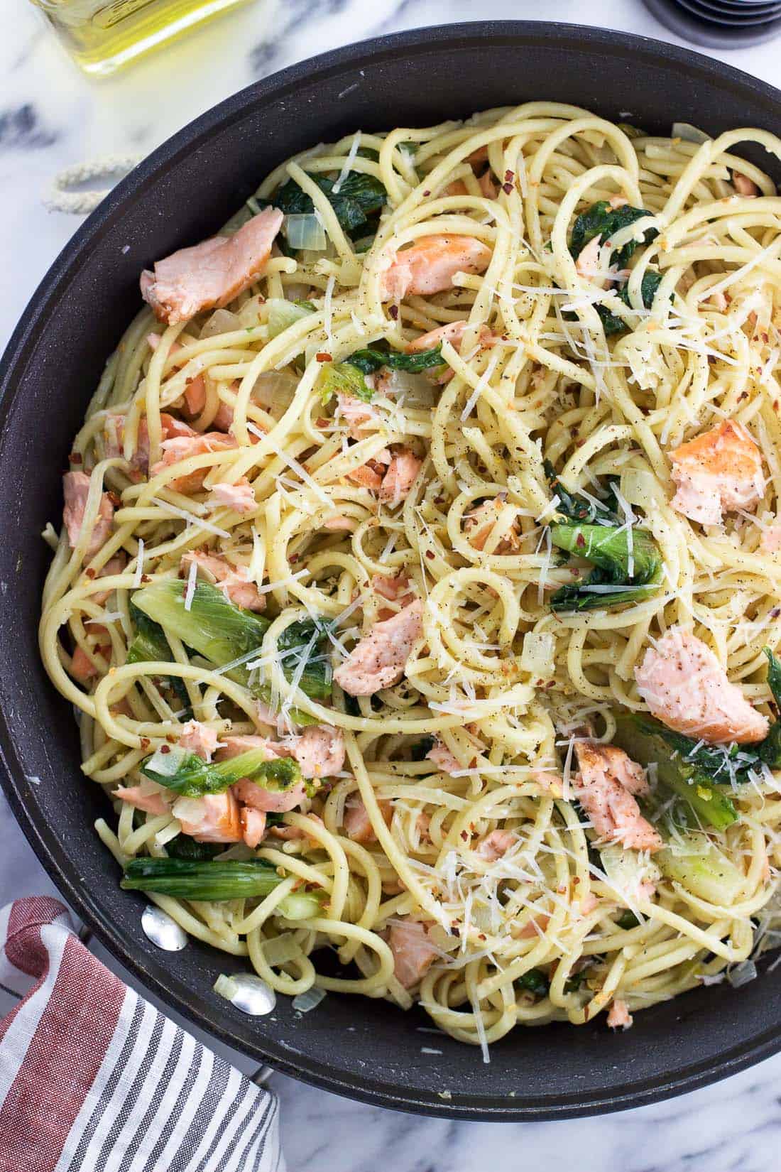 Bucatini, salmon, escarole, and grated cheese tossed together in a skillet