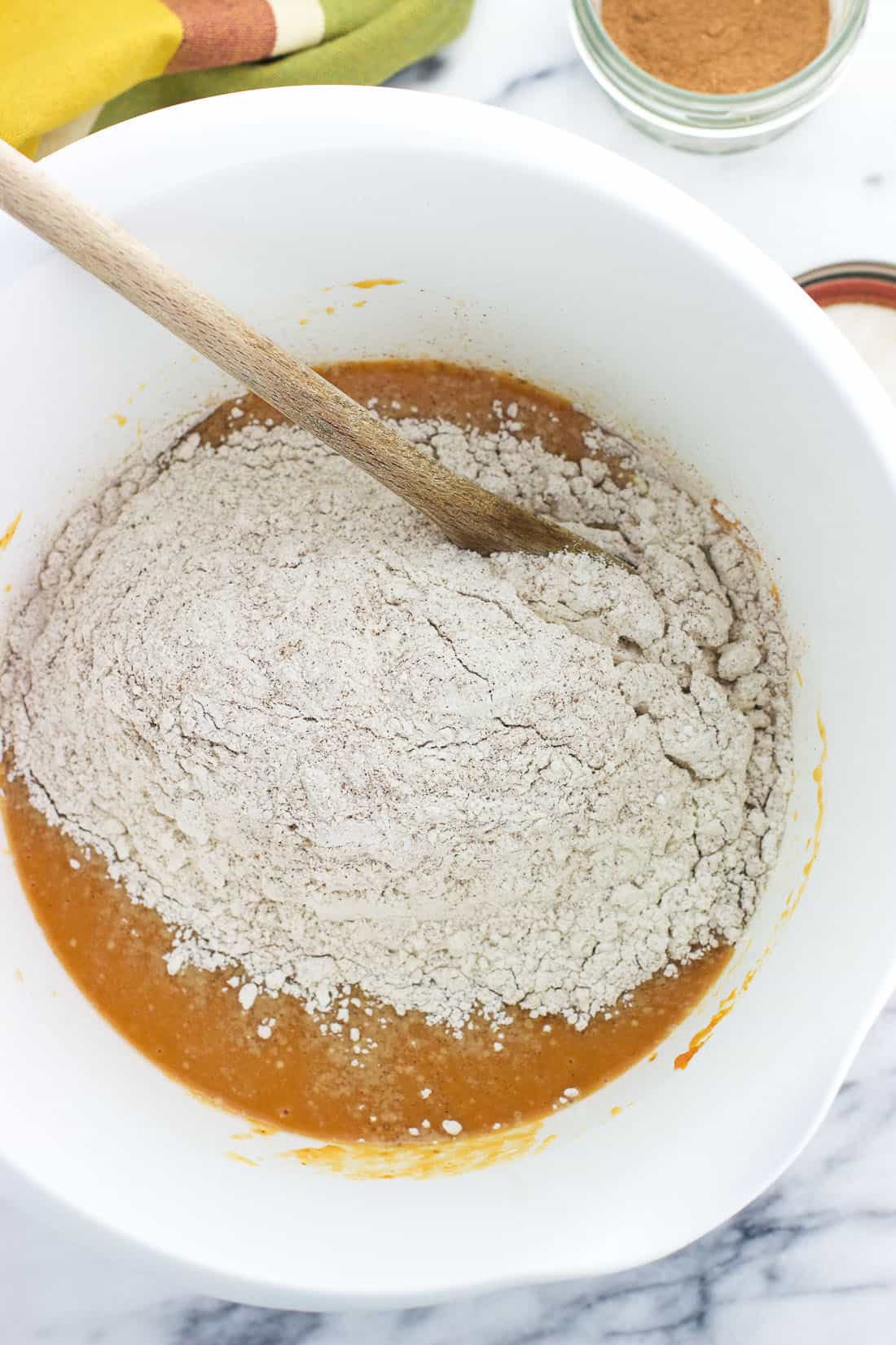 The dry ingredients poured into the bowl with the wet ingredients before being stirred together.