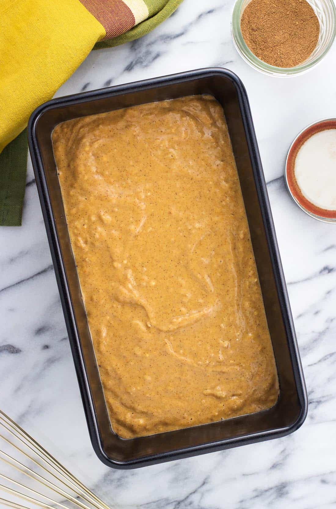 An overhead shot of the batter in a loaf pan before baking.