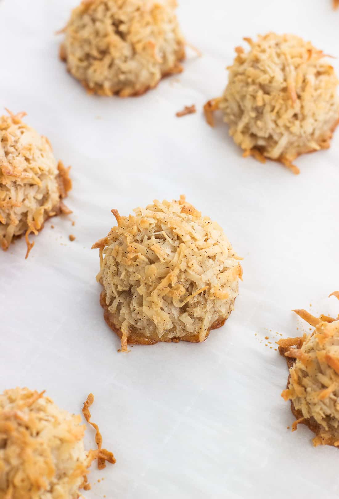 Baked macaroons on a parchment-lined baking sheet.