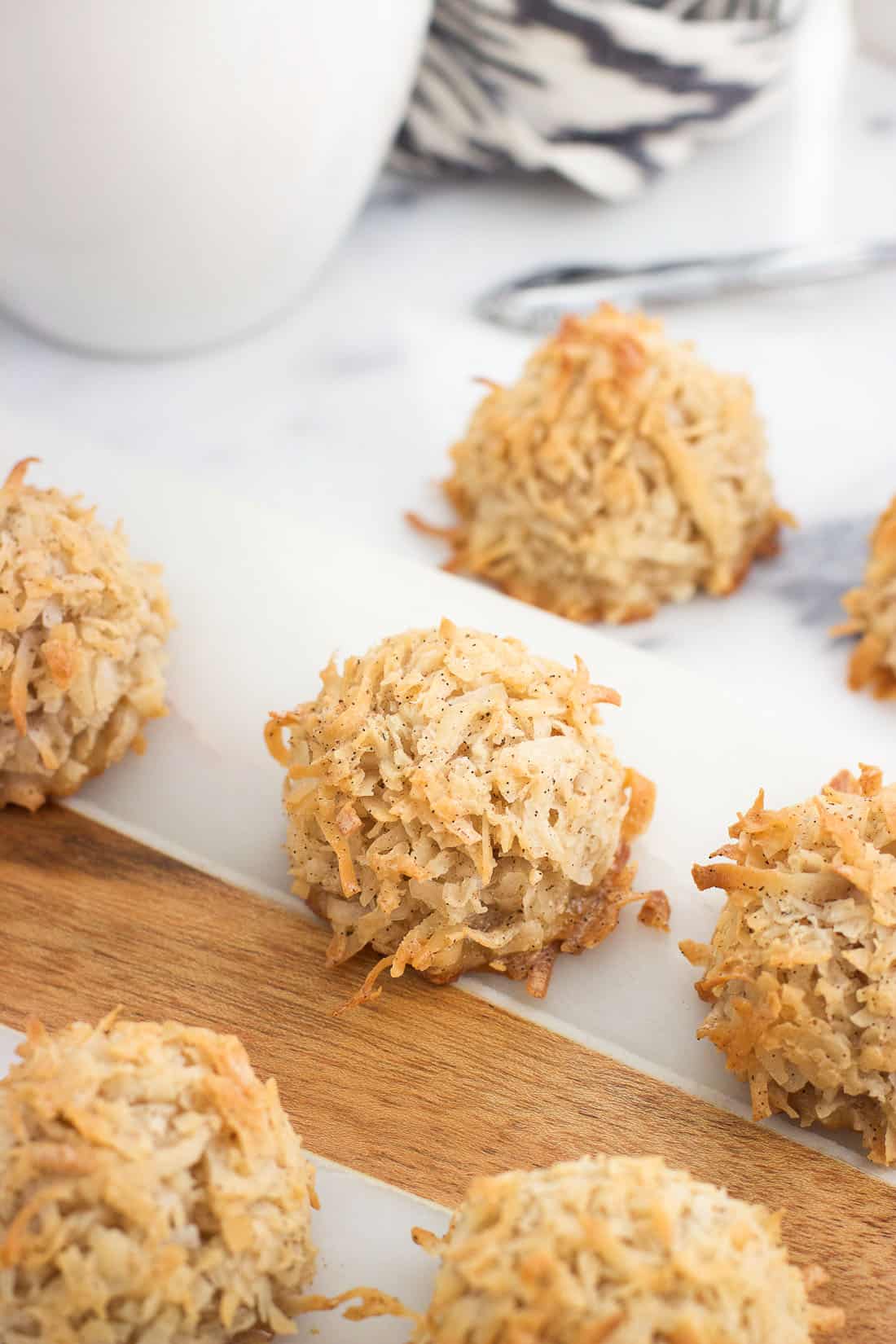 Macaroons on a marble serving board surrounded by a mug of chai tea.