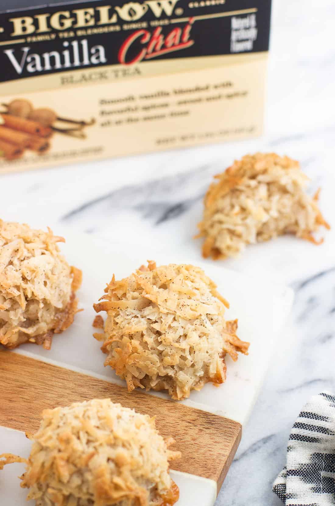 Macaroons on a marble serving board with a box of Bigelow Vanilla Chai Tea in the background.