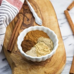 All five spices in this chai blend segmented out in a small ceramic bowl