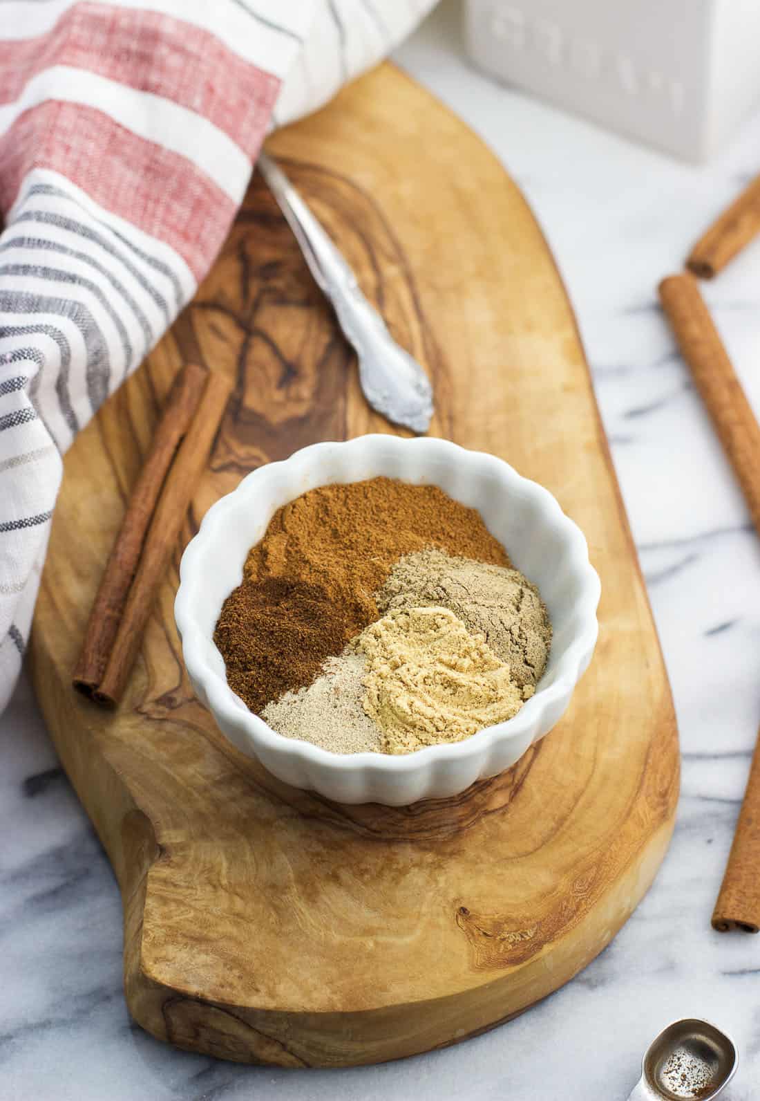 A small ceramic bowl filled with the five spices in the chai blend, all separated out into wedges