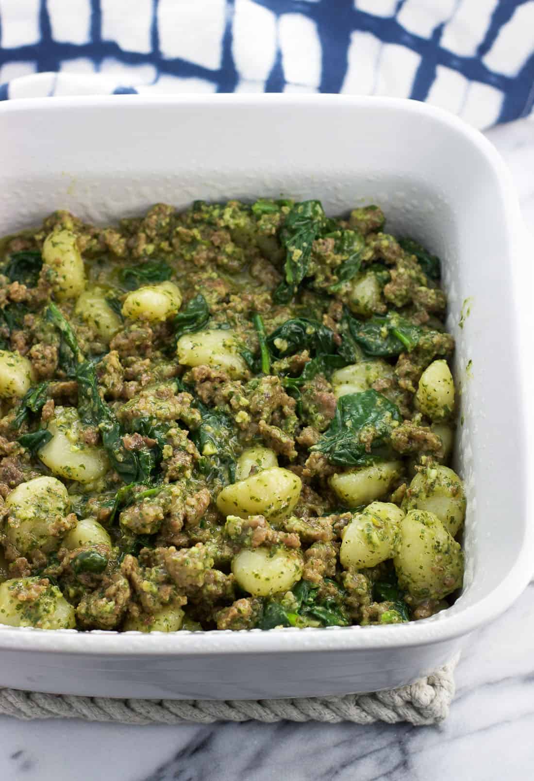 Gnocchi, crumbled sausage, spinach, and pesto sauce combined in a large square baking dish