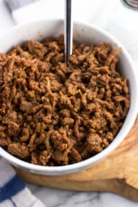 A bowl of taco meat with a spoon.