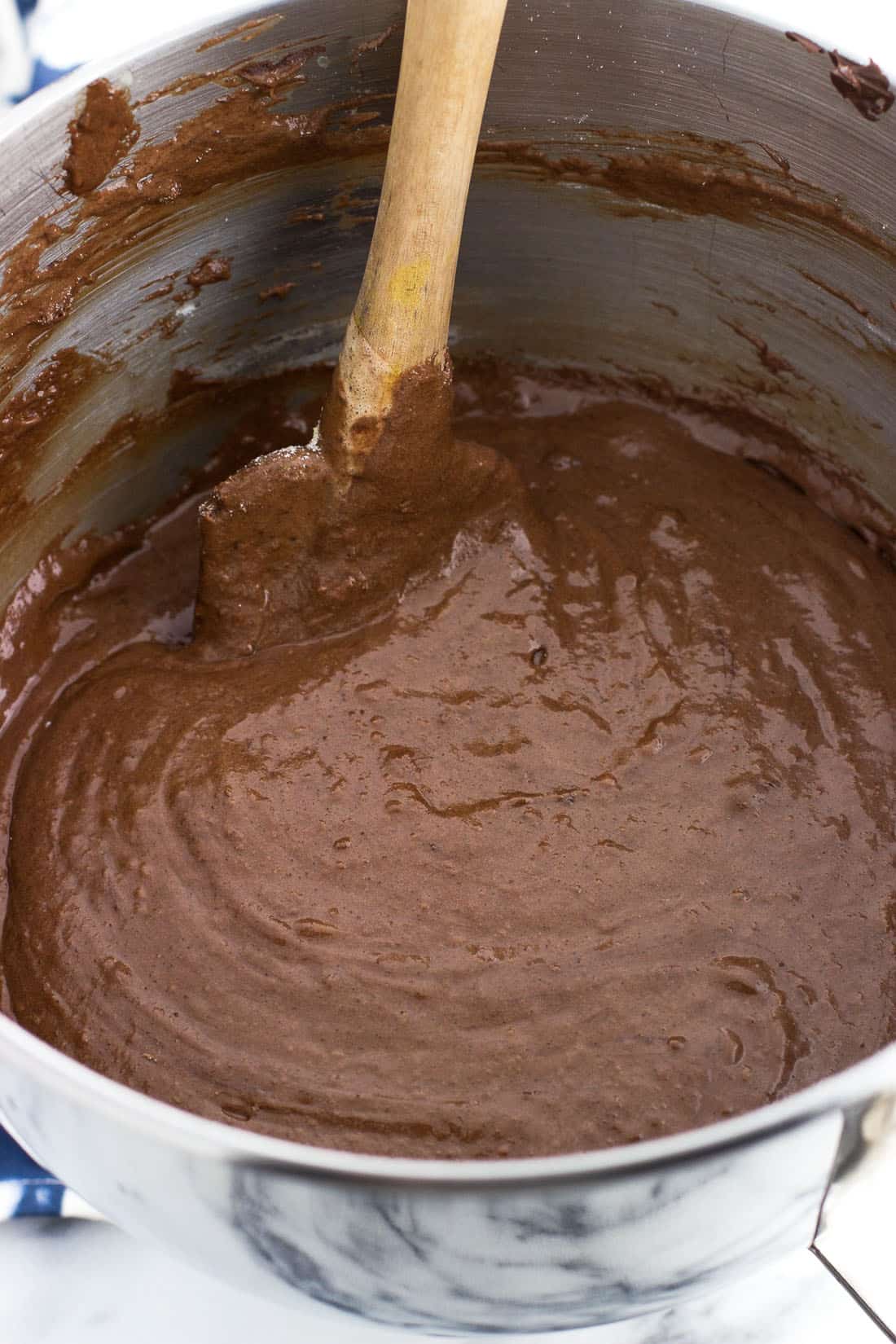 Cookie batter in a metal stand mixer bowl with a spatula in it