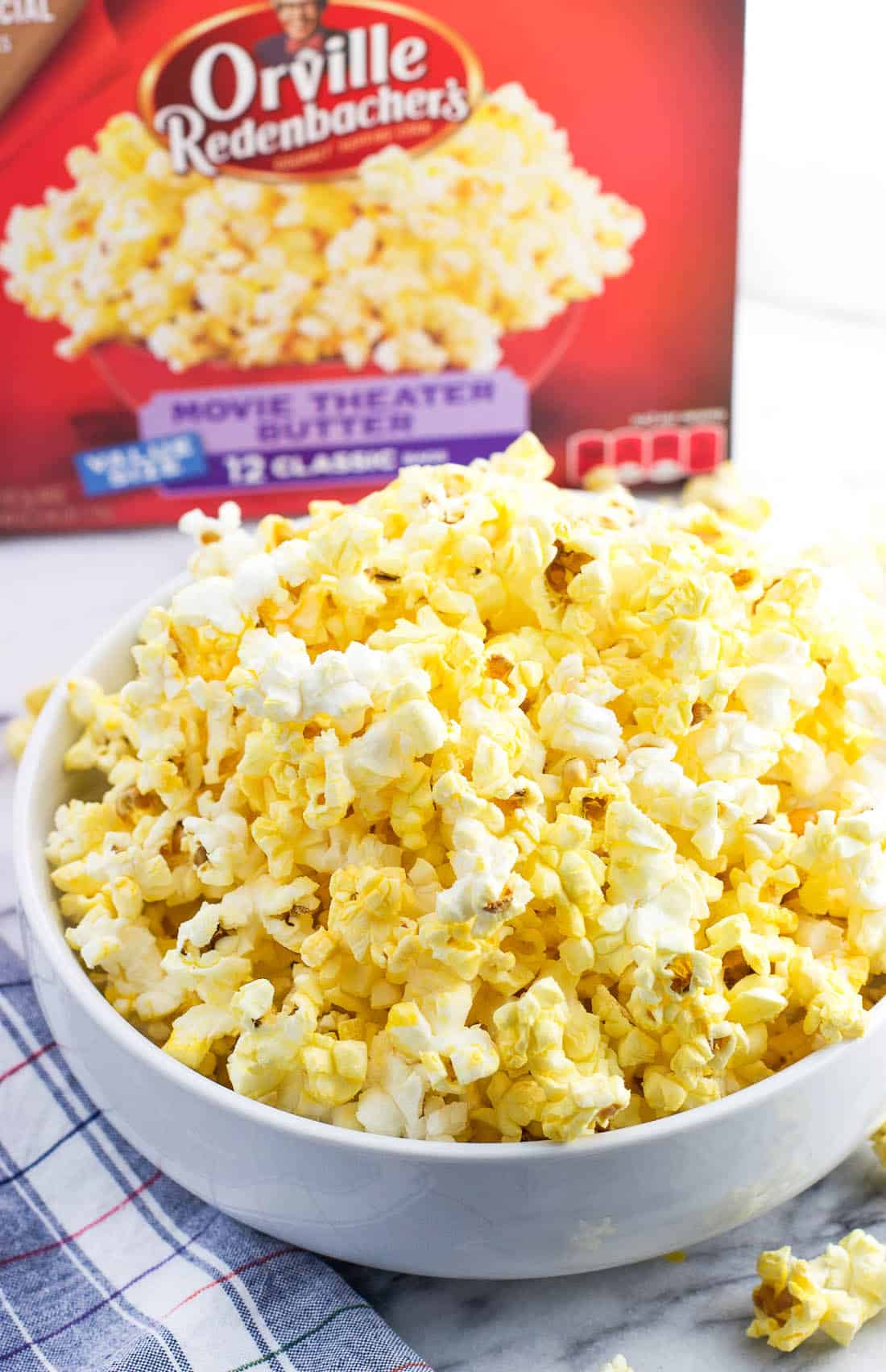 A bowl of popped popcorn next to the Orville Redenbacher's box